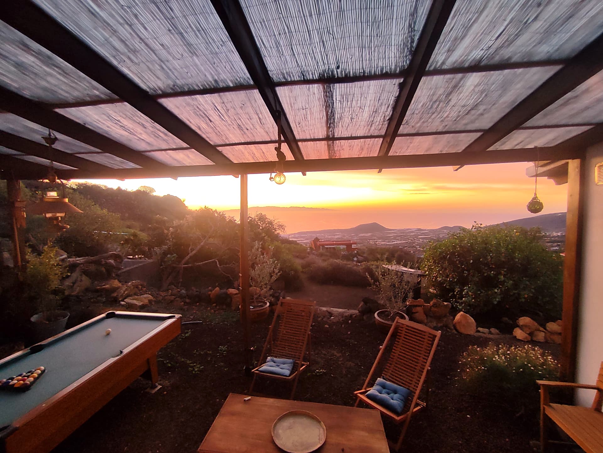 Terrasse couverte avec billard et chaises longues face au coucher de soleil sur l'océan